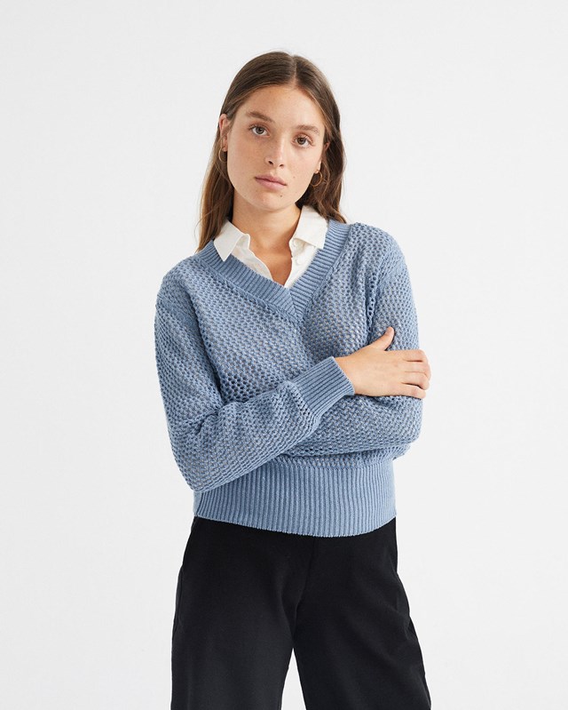 Femme porte pull bleu vue de face buste