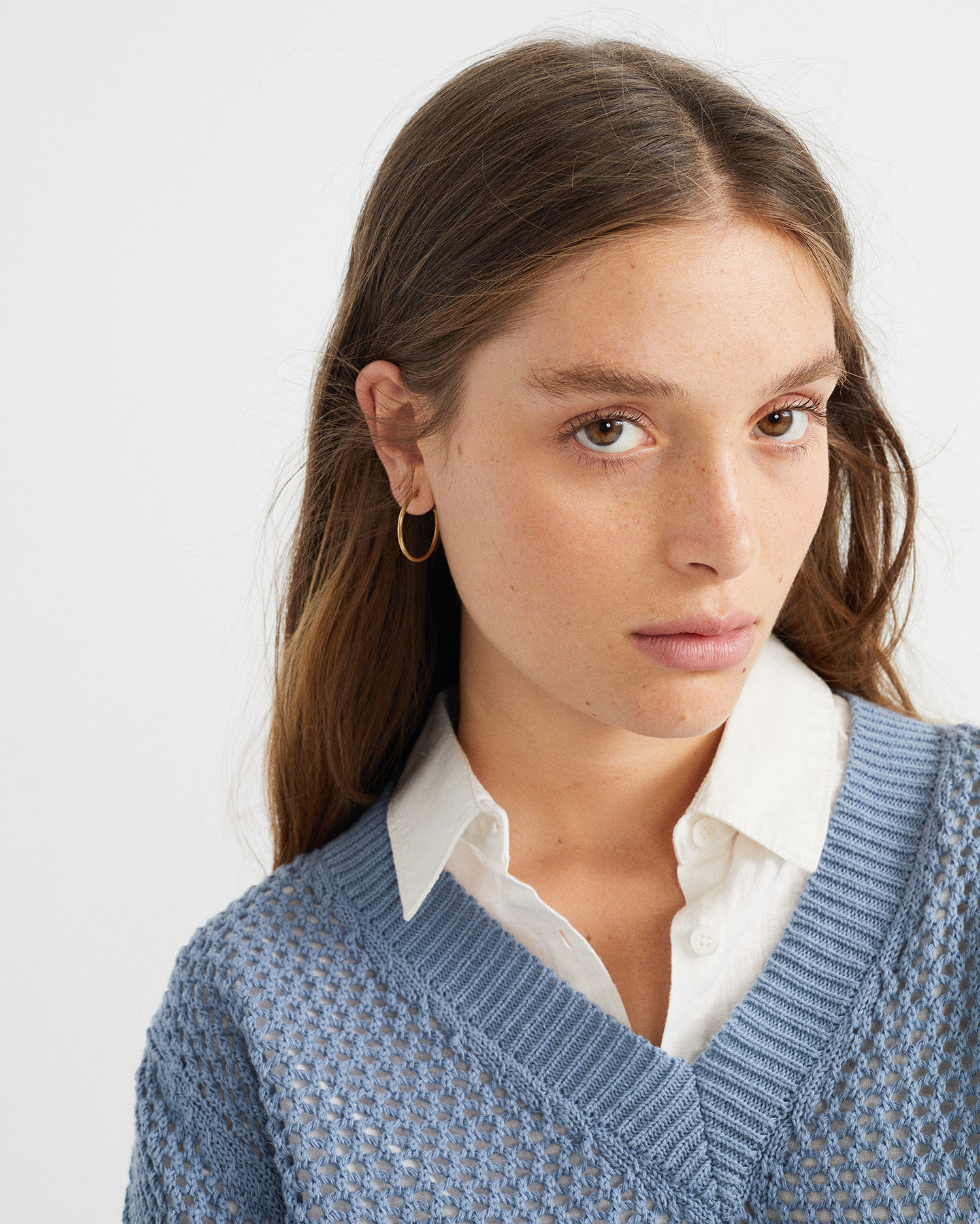 Femme porte pull bleu détail col V