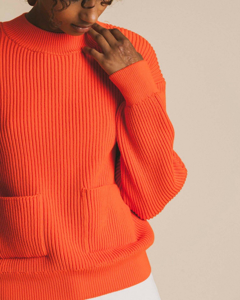 Femme porte pull orange zoom sur tronc