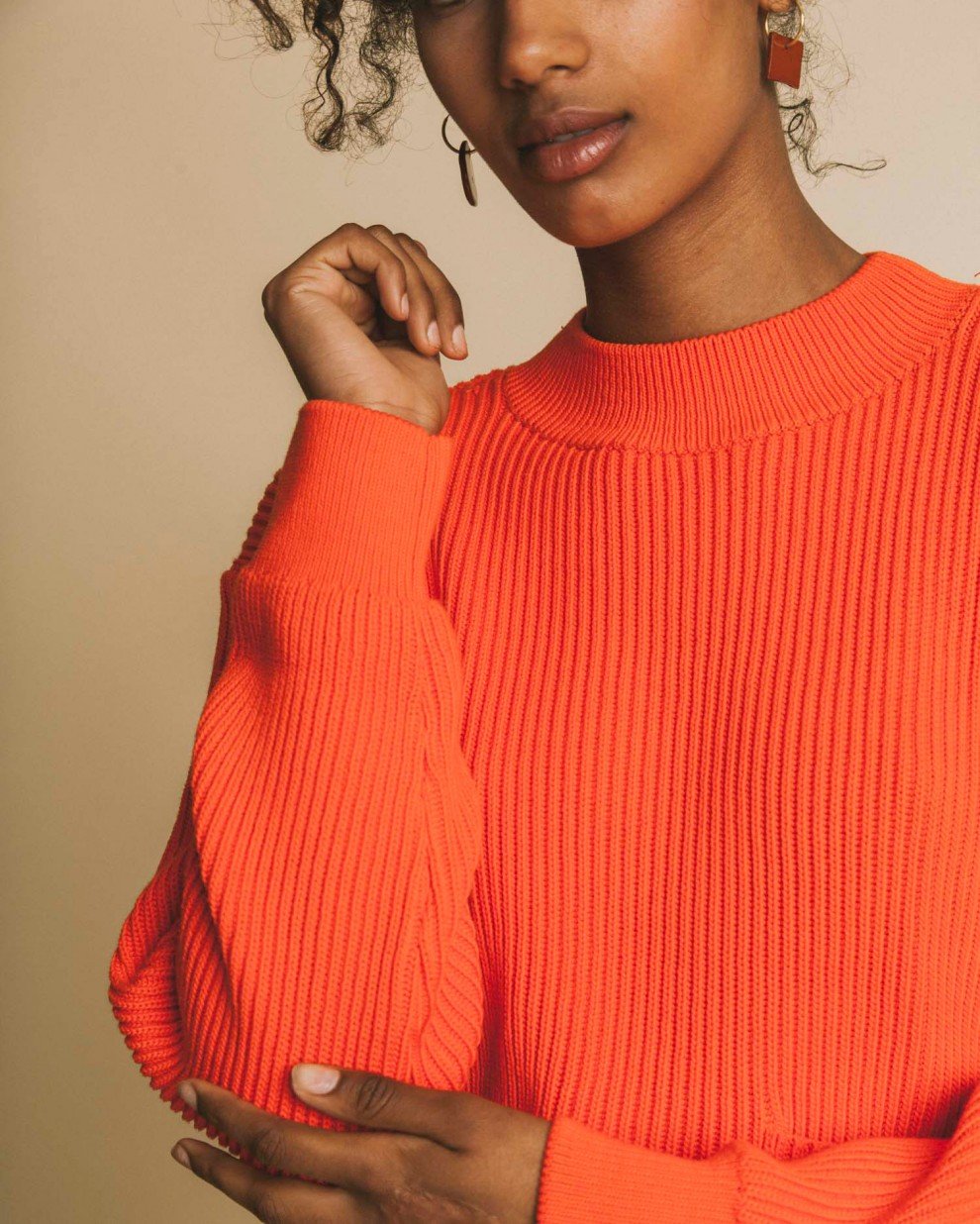 Femme porte pull orange zomm sur manche