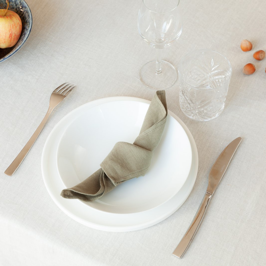 Exemple de dressage de la nappe en lin écrue et d'une serviette kaki