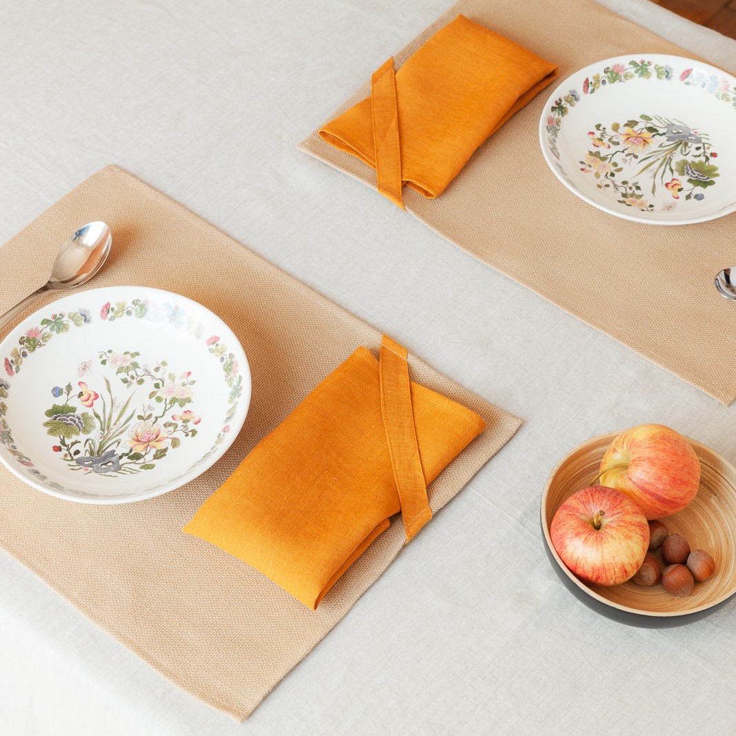 dressage du linge de table en lin ocre : une nappe écrue, deux sets de table et deux serviettes ocre