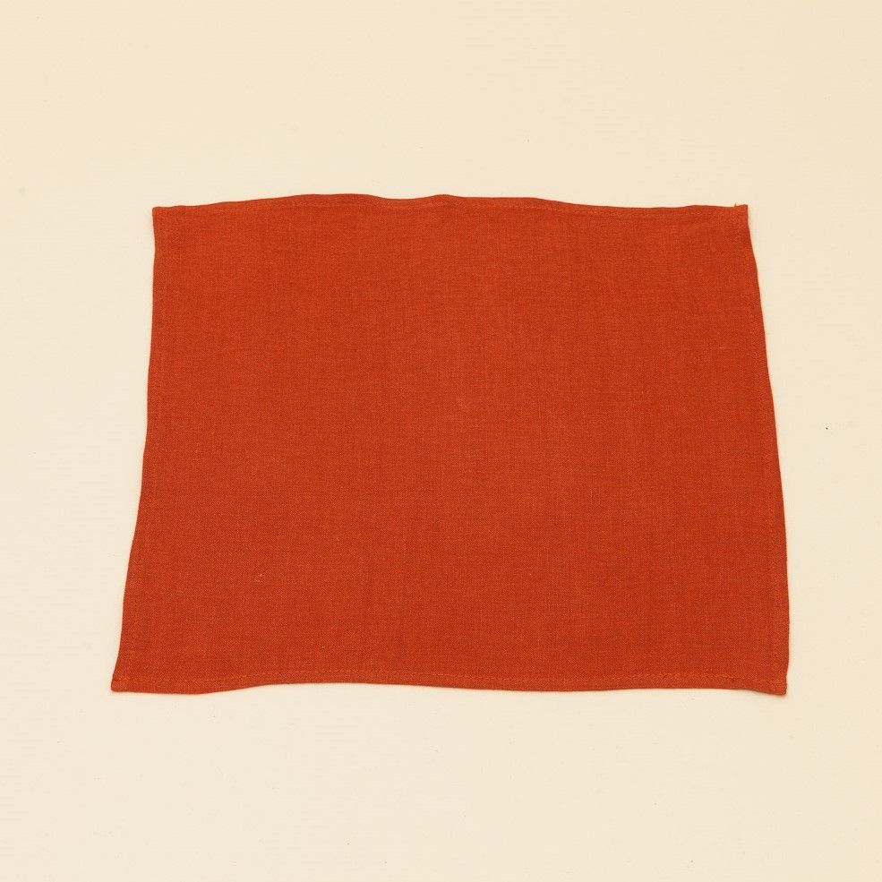 une serviette de table en lin rouge brique