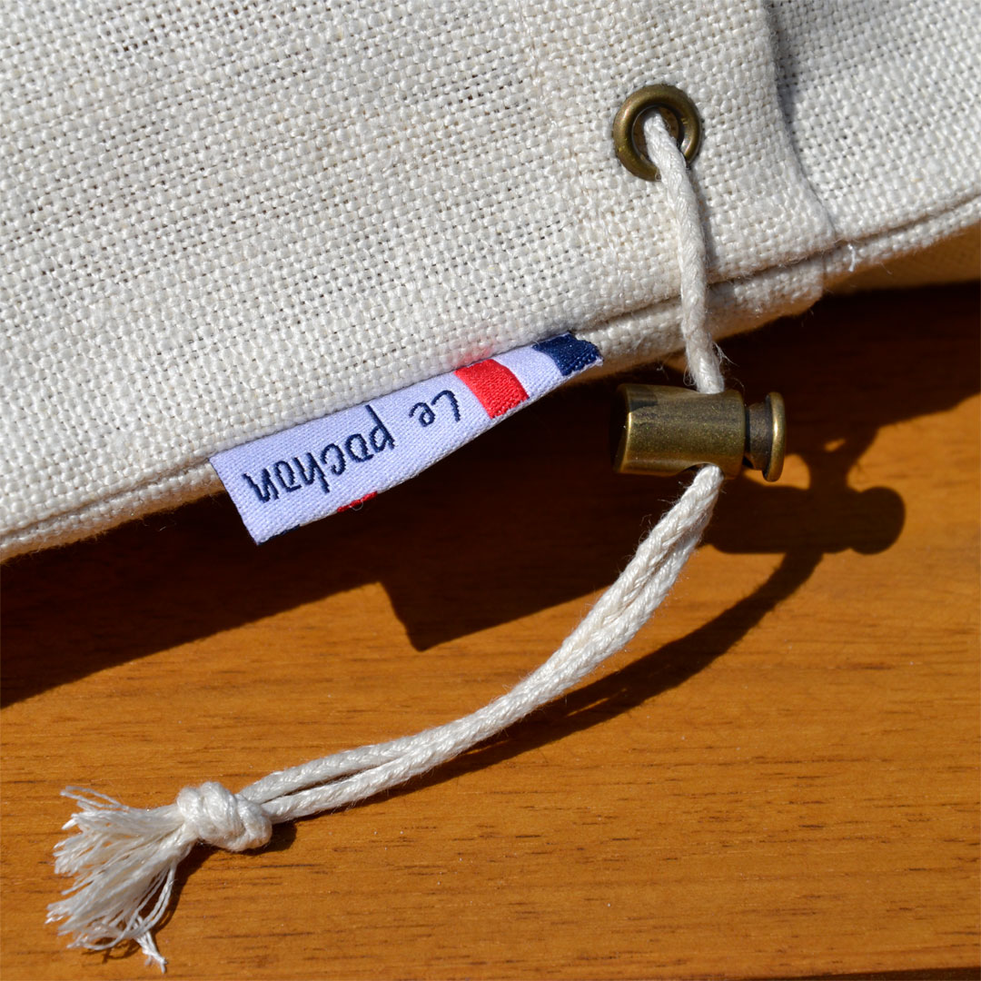 Zoom sur le cordon et l'étiquette du sac à pain le pochon beige