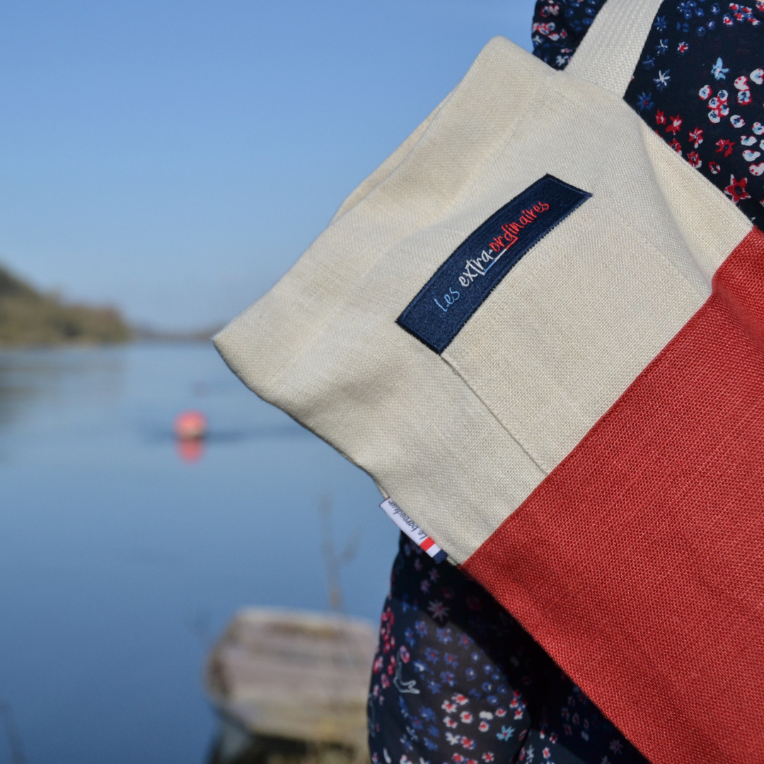 Sac à pain le baroudeur rouge porté par une femme devant un fleuve