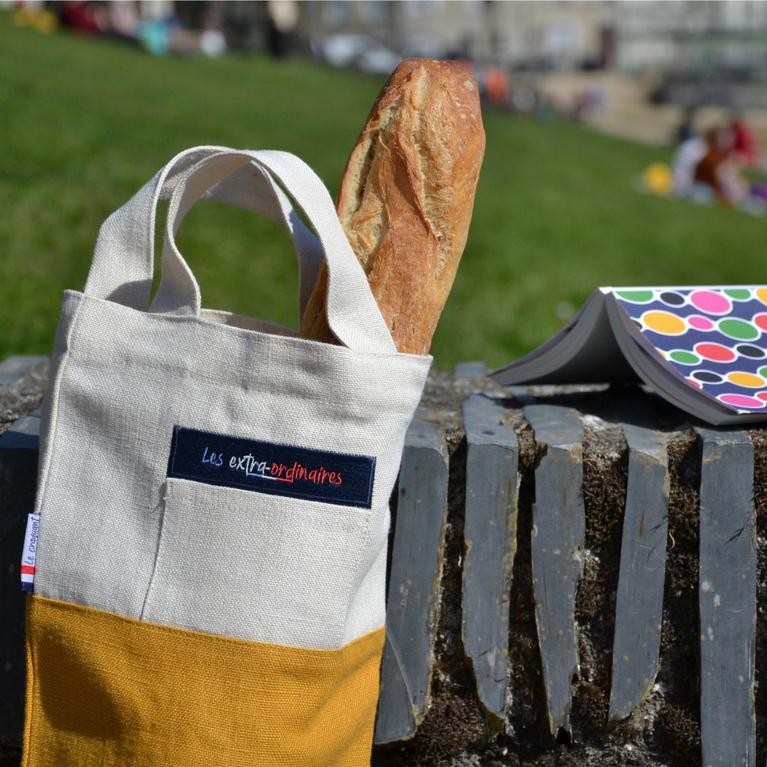 Sac à pain le craquant jaune devant une pelouse