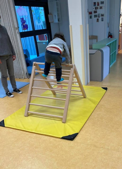 Enfant escaladant le triangle de motricité libre