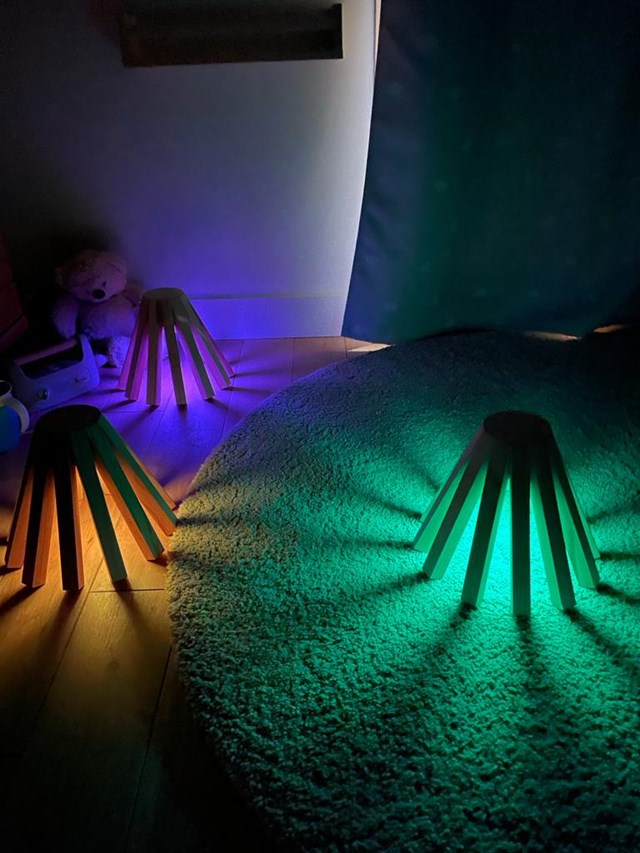 Trois veilleuses avec différentes couleurs de lumière : violet, orange et vert