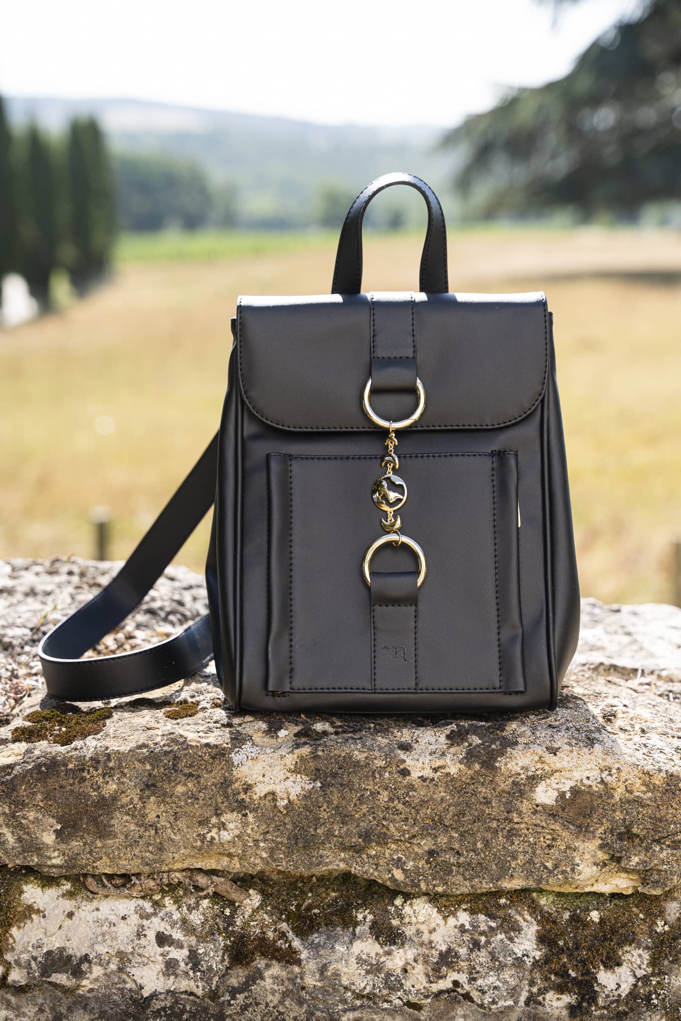 sac noir végan avec un bijou doré et bretelles réglables