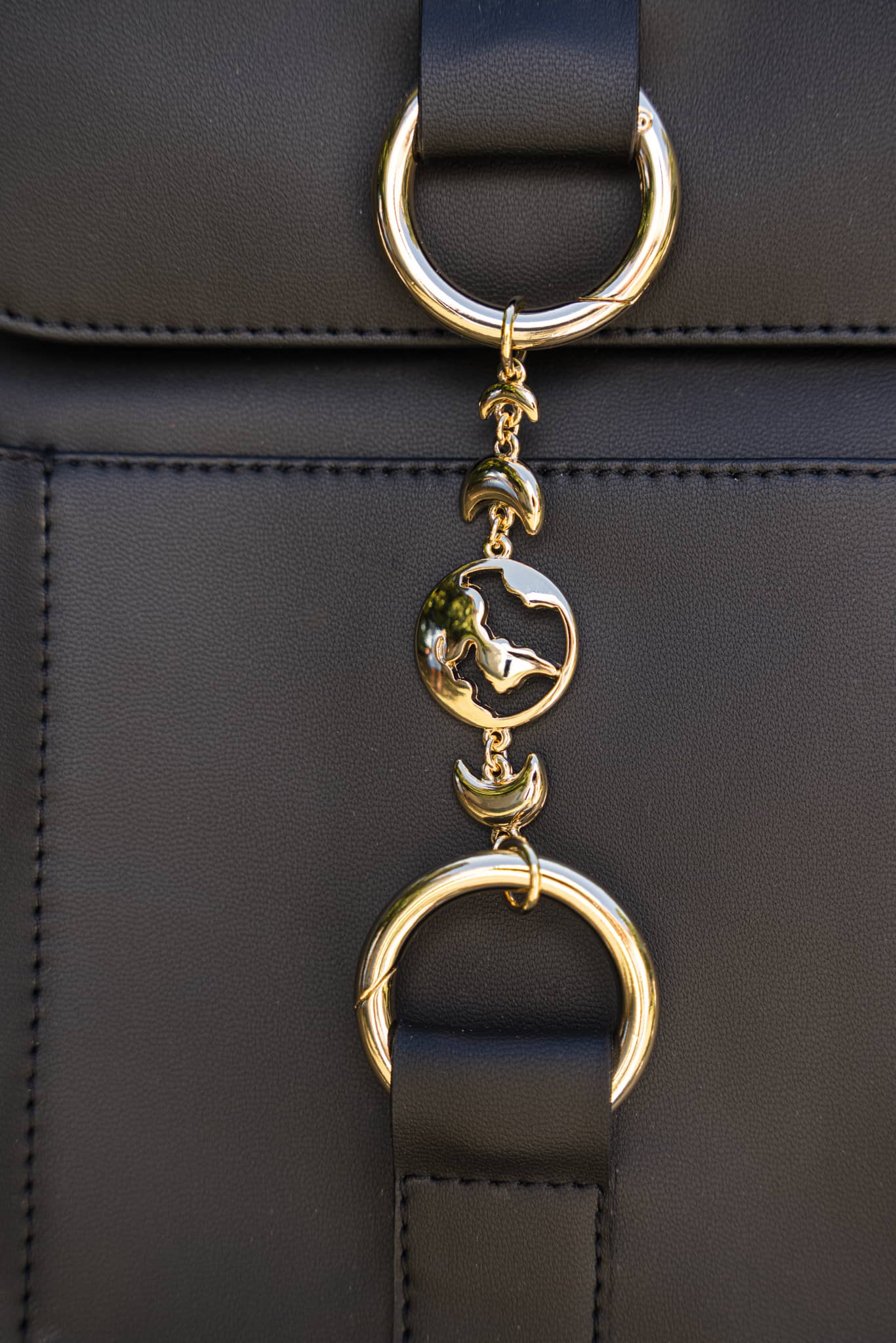 sac noir végan avec un bijou doré et bretelles réglables