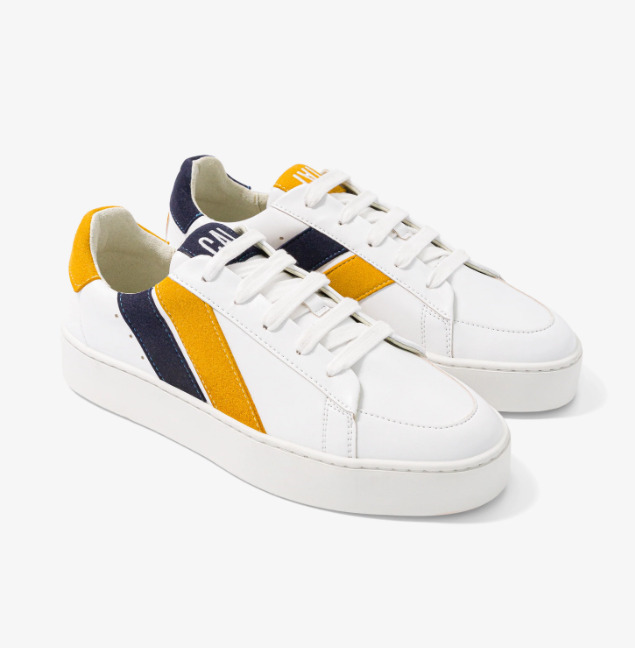 baskets en cuir blanches avec deux rayures asymétriques noir et jaune. Logo à l'arrière.
