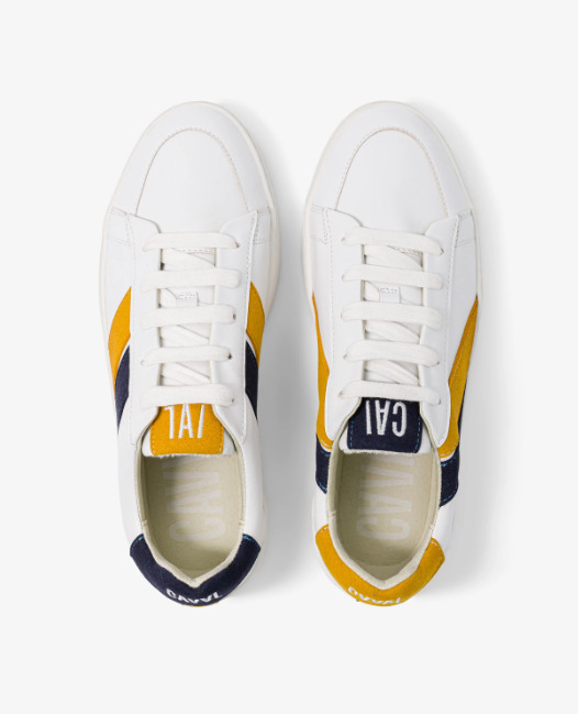 baskets en cuir blanches avec deux rayures asymétriques noir et jaune. Logo à l'arrière.