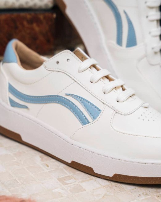 baskets blanches avec empiècements de couleurs bleu clair sur les cotés et derrière, lacets blancs