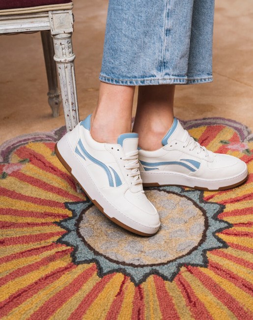 baskets blanches avec empiècements de couleurs bleu clair sur les cotés et derrière, lacets blancs